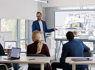 Mitarbeiter folgen einer Präsentation am Whiteboard